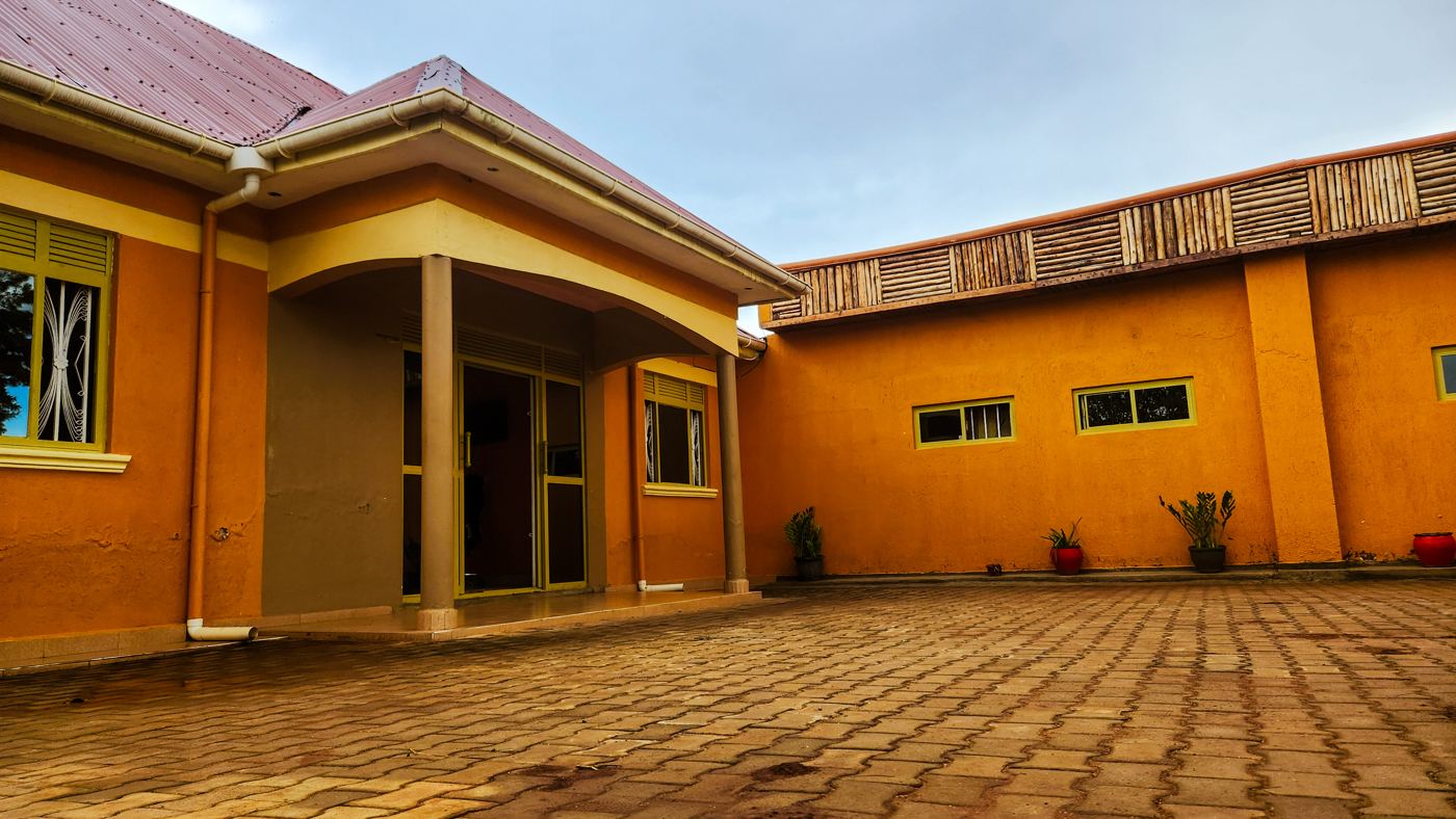 Terracotta-coloured guest wing with paved courtyard