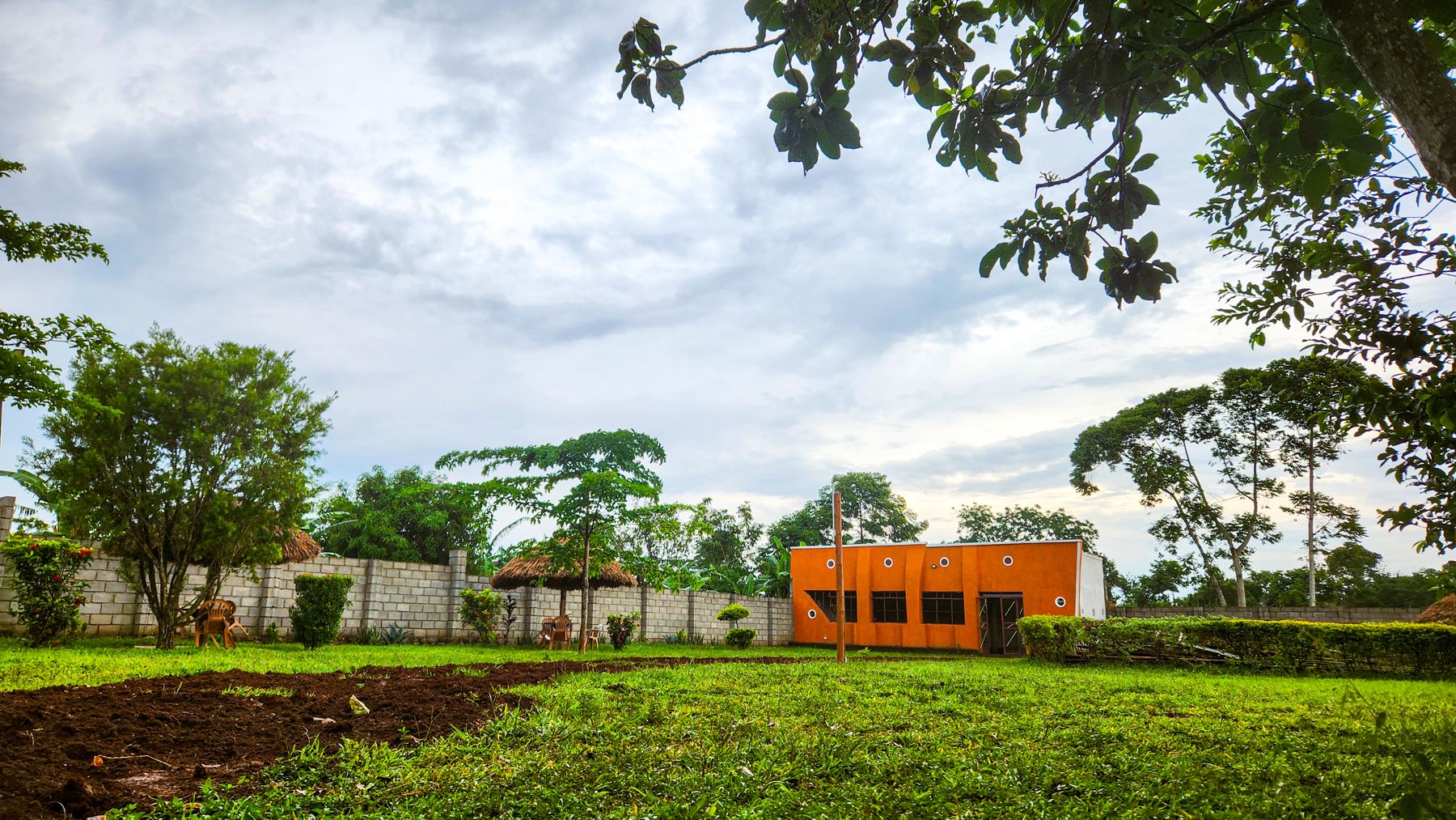 Lawns and trees at Butende Resort with the guest wing in the background