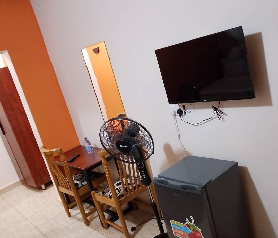 Room with desk, fridge and TV
